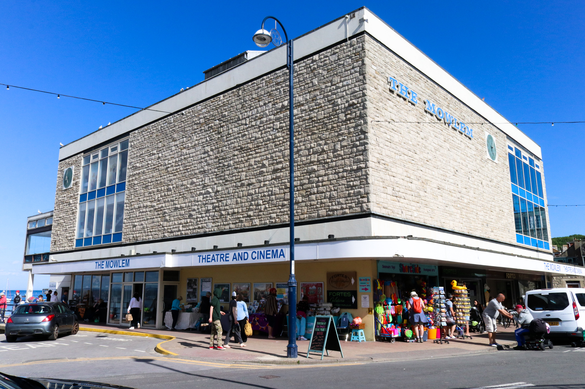The Mowlem theatre and cinema on the Swanage seafront, a stone-clad building on a street corner